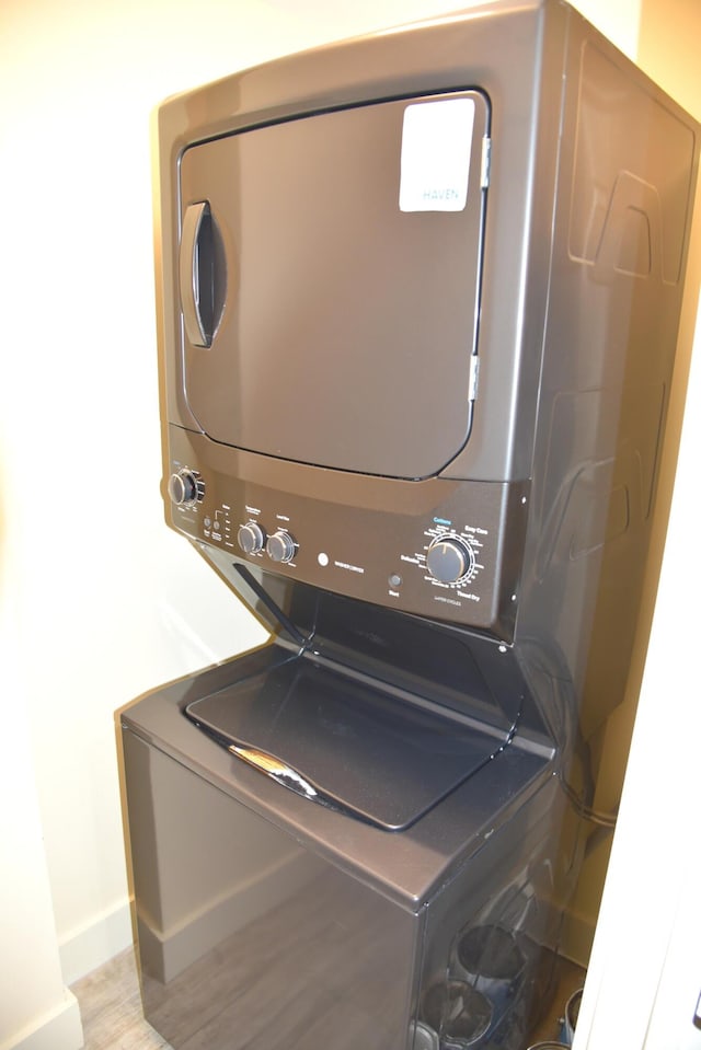 9200 Baytowne Wharf Blvd Unit 444/446, Miramar Beach, FL 32550 - laundry area featuring stacked washing machine and dryer, baseboards, and wood finished floors
