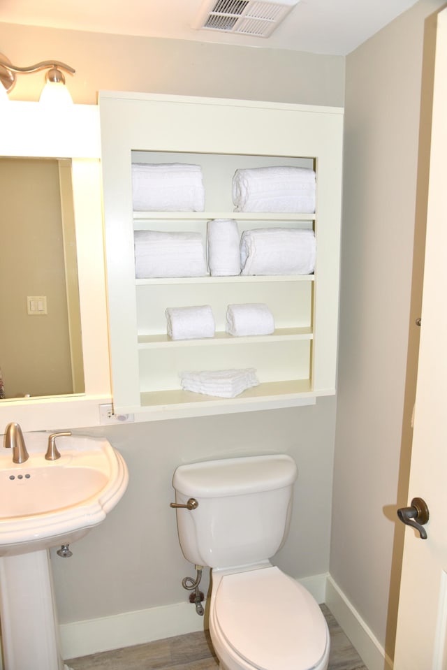 bathroom featuring hardwood / wood-style floors and toilet