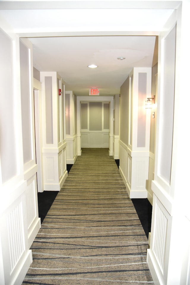 corridor featuring dark colored carpet