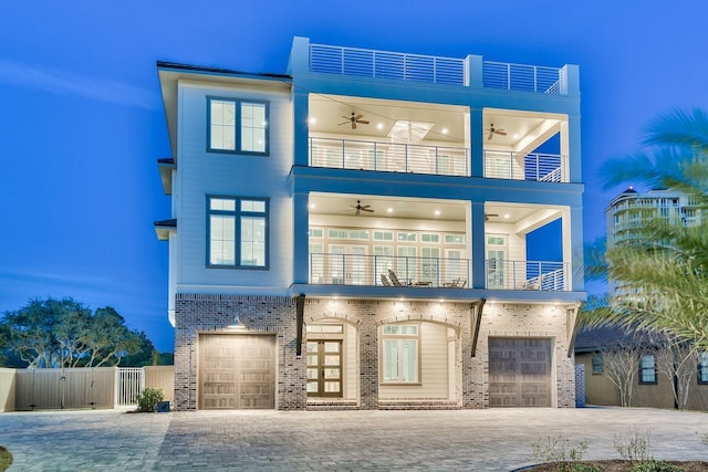 view of front of house featuring ceiling fan, a garage, and a balcony