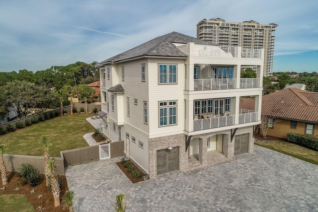 back of property featuring a lawn, a balcony, and a garage