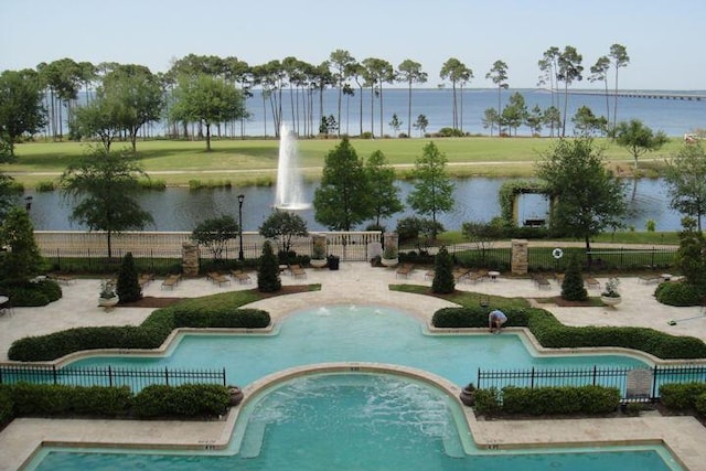 view of pool with a water view and fence