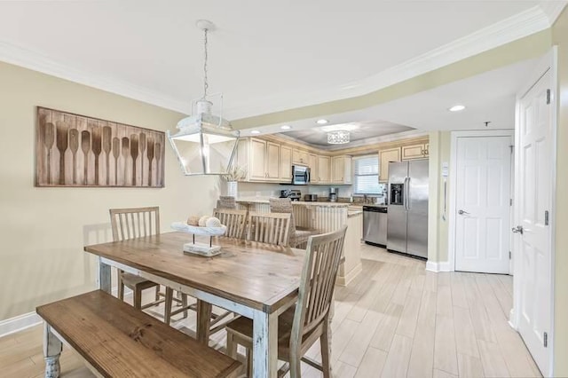 dining space with light hardwood / wood-style flooring and crown molding