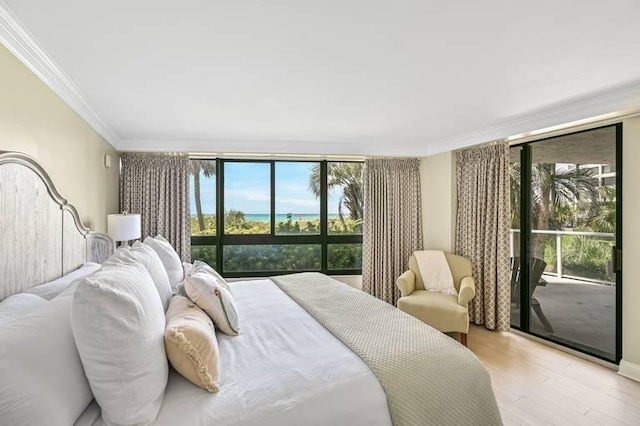 bedroom with access to exterior, light wood-type flooring, multiple windows, and ornamental molding