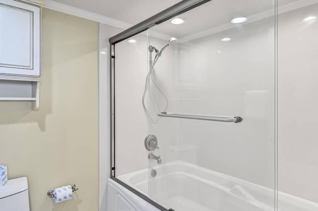 bathroom with crown molding, enclosed tub / shower combo, and toilet