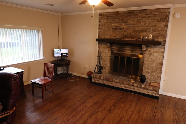 living room with dark hardwood / wood-style floors, a brick fireplace, ceiling fan, and ornamental molding