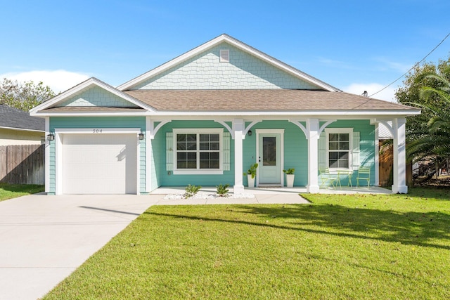 view of front of home featuring covered porch, a front yard, and a garage