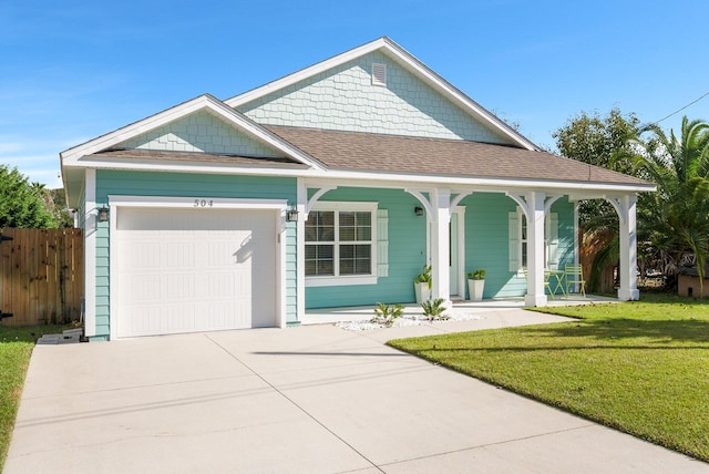 view of front of house featuring covered porch, a garage, and a front lawn