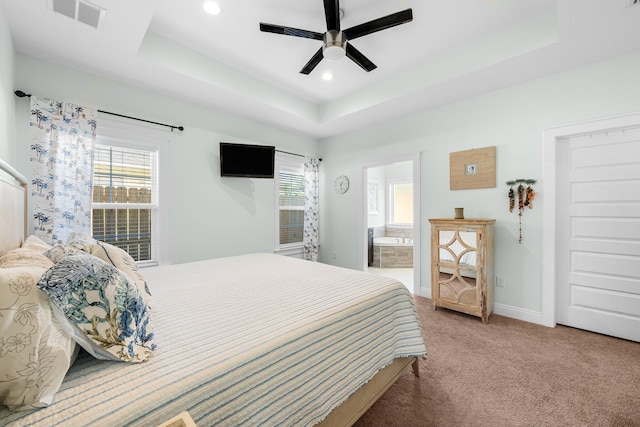 carpeted bedroom with ceiling fan, connected bathroom, and a tray ceiling