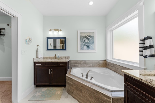 bathroom featuring vanity and tiled tub