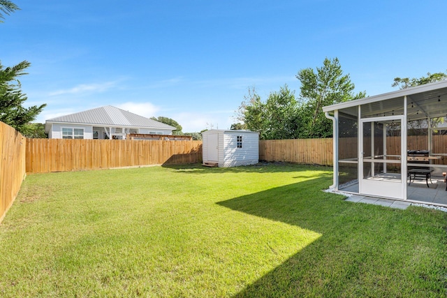 view of yard featuring a sunroom and a storage shed