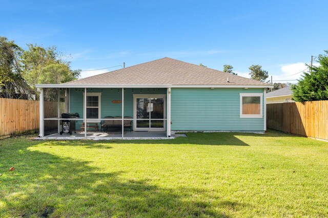 rear view of house with a sunroom and a lawn