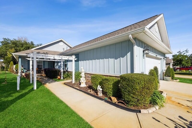 view of property exterior featuring a pergola, a yard, and a garage