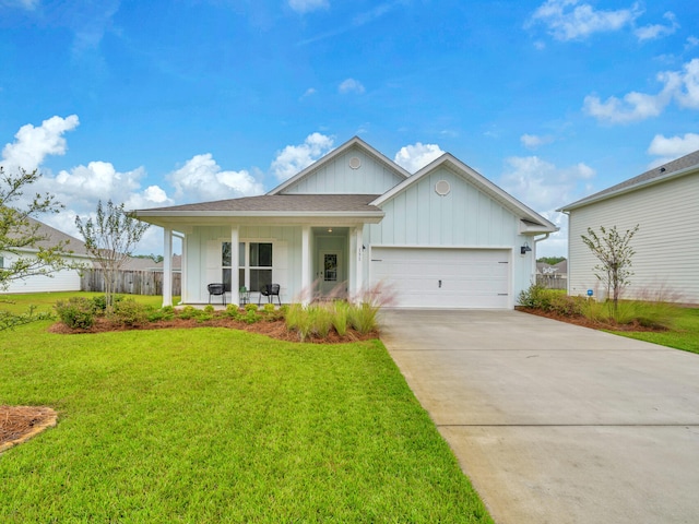 view of front of property with covered porch, a garage, and a front lawn