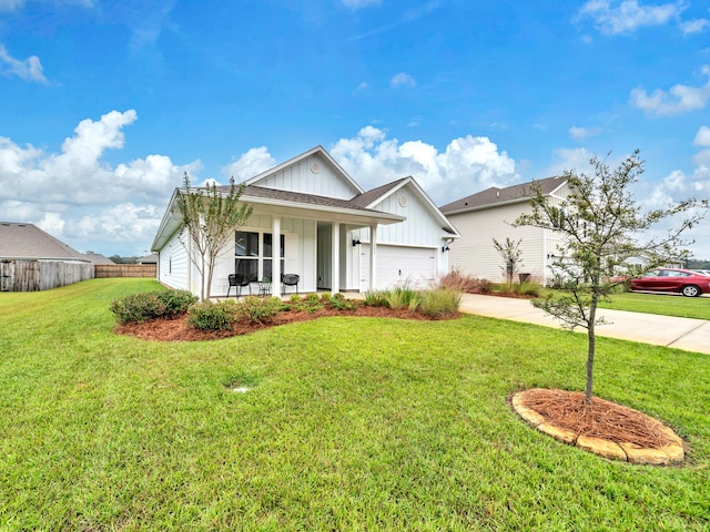 view of front of property with a front yard, a garage, and covered porch