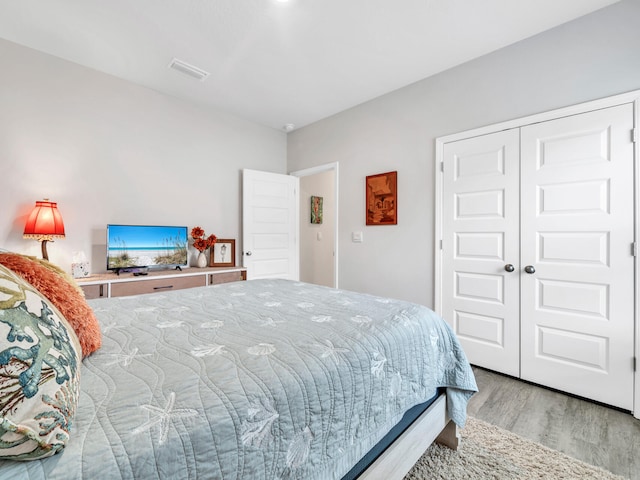 bedroom with light hardwood / wood-style floors and a closet