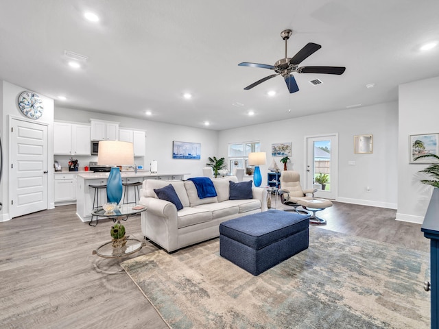 living room featuring light hardwood / wood-style floors and ceiling fan