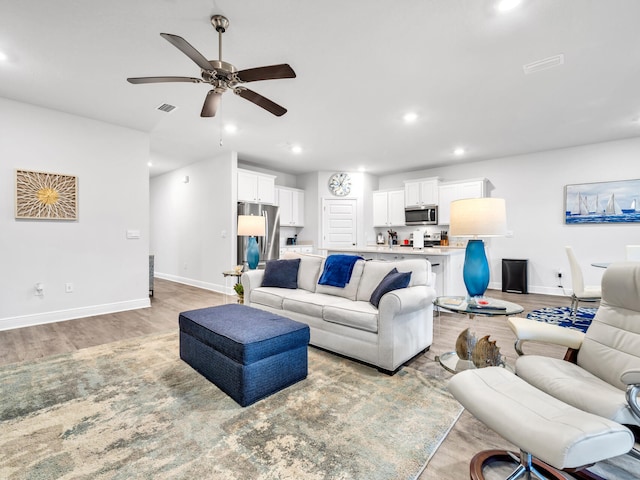 living room with light hardwood / wood-style floors and ceiling fan