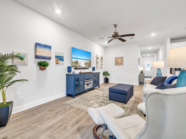 living room featuring ceiling fan and hardwood / wood-style floors