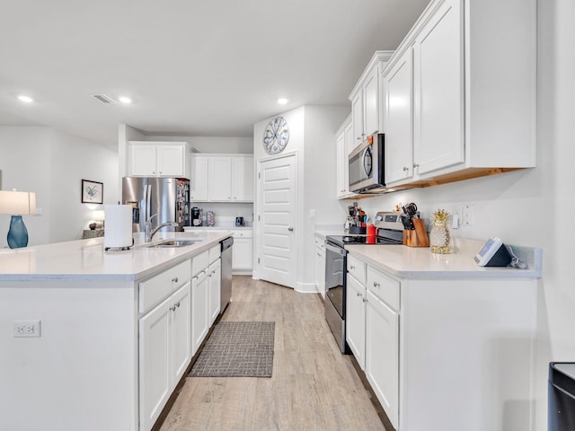 kitchen with white cabinetry, sink, light wood-type flooring, and appliances with stainless steel finishes