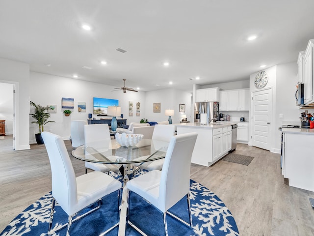 dining space with light hardwood / wood-style floors and ceiling fan