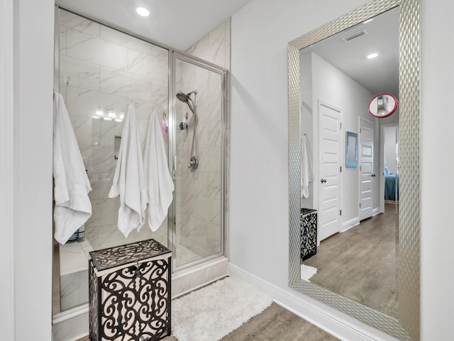 bathroom featuring hardwood / wood-style floors and a shower with door