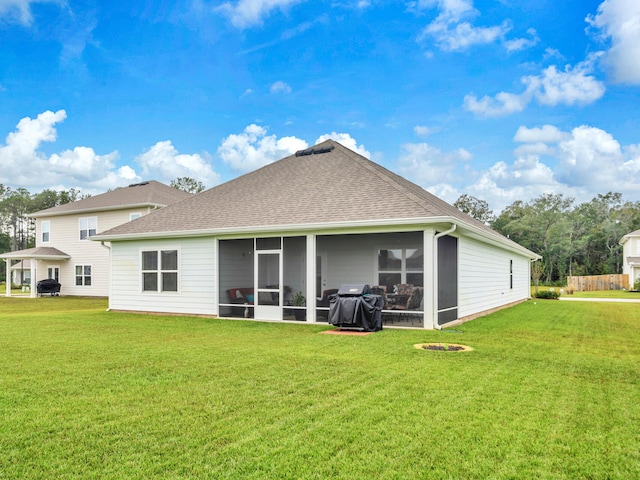 back of property with a lawn and a sunroom