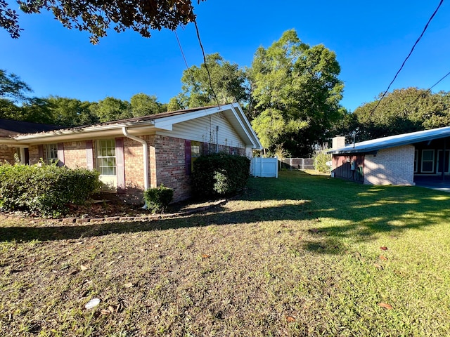 view of side of home with a yard