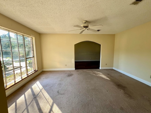 carpeted empty room with plenty of natural light, ceiling fan, and a textured ceiling