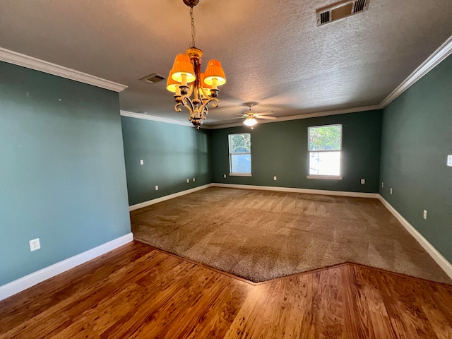 spare room featuring a textured ceiling, ceiling fan with notable chandelier, wood-type flooring, and ornamental molding