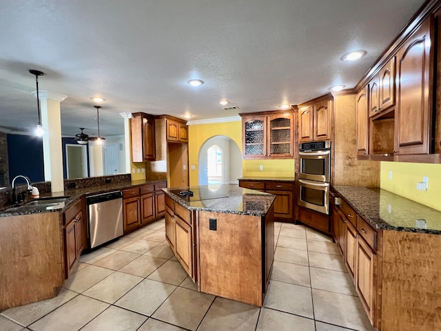 kitchen featuring sink, light tile patterned floors, decorative light fixtures, a kitchen island, and stainless steel appliances