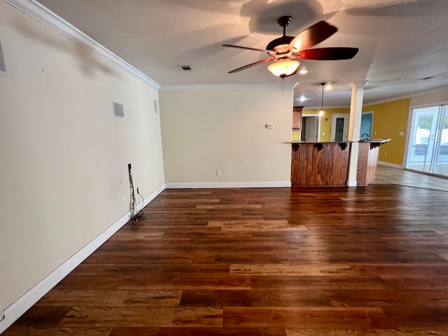 unfurnished living room featuring dark hardwood / wood-style floors, ceiling fan, and crown molding