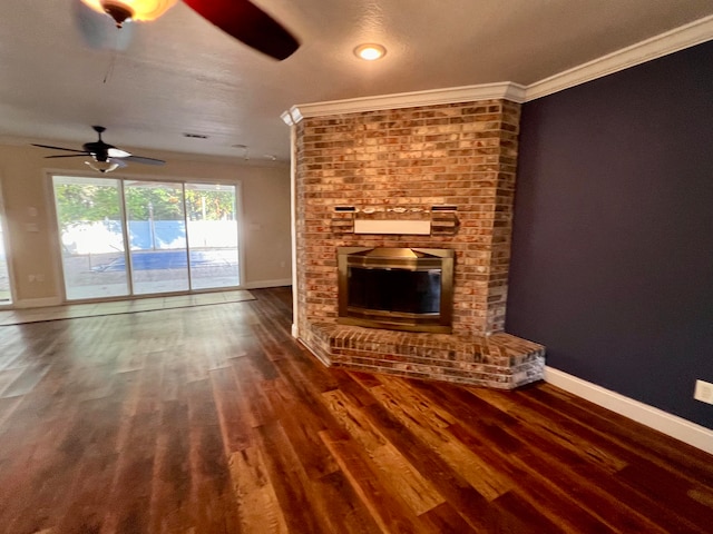 unfurnished living room featuring a brick fireplace, ceiling fan, dark hardwood / wood-style floors, and ornamental molding