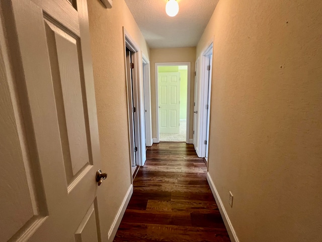 hall featuring dark hardwood / wood-style flooring and a textured ceiling