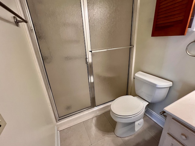 bathroom with tile patterned flooring, vanity, toilet, and a shower with shower door