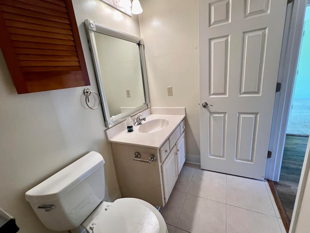 bathroom with toilet, vanity, and tile patterned floors