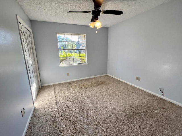 unfurnished bedroom featuring carpet flooring, a textured ceiling, a closet, and ceiling fan