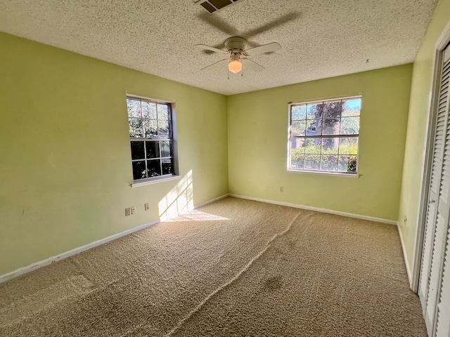 unfurnished bedroom featuring carpet, ceiling fan, a textured ceiling, and a closet