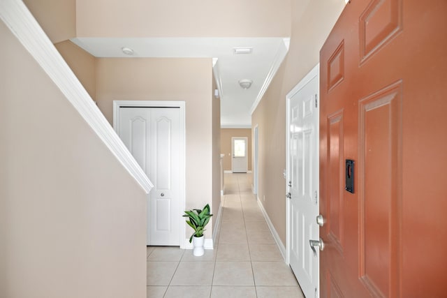 hallway featuring crown molding and light tile patterned floors