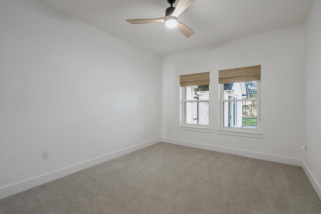 carpeted spare room with ceiling fan