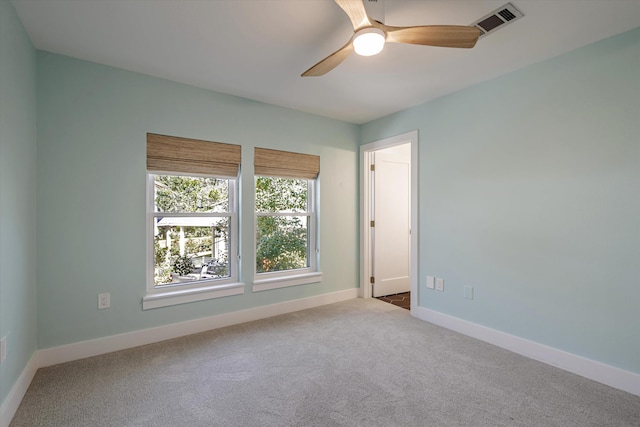 unfurnished room with light colored carpet and ceiling fan