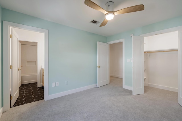 unfurnished bedroom with carpet flooring, connected bathroom, a closet, and ceiling fan