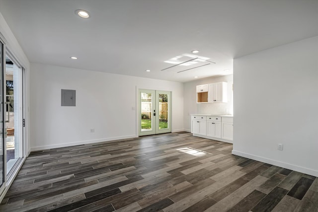 unfurnished living room with dark hardwood / wood-style floors, electric panel, and french doors