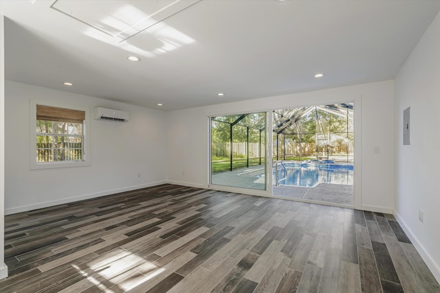 unfurnished room with an AC wall unit, dark hardwood / wood-style flooring, plenty of natural light, and electric panel