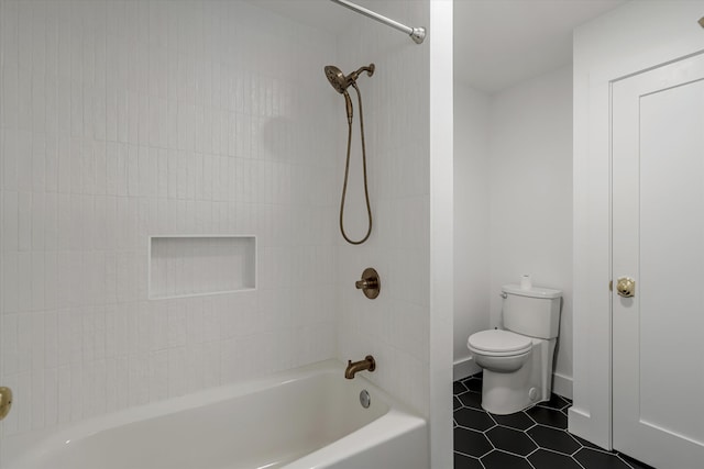 bathroom featuring tile patterned floors, toilet, and tiled shower / bath