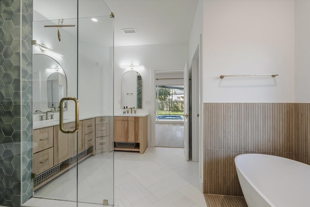 bathroom featuring vanity and independent shower and bath