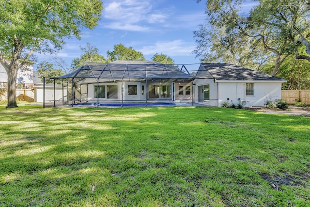 back of property with a lanai and a lawn