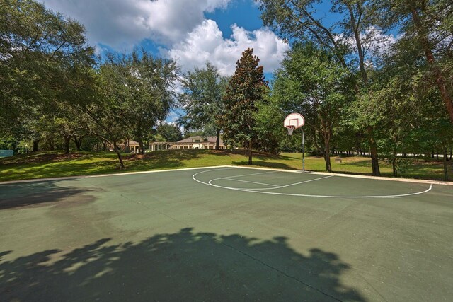 view of sport court with a lawn