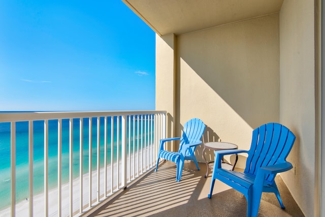 balcony featuring a water view and a beach view