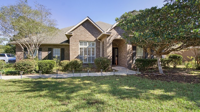 446 Mango Ln, Freeport, FL 32439 - view of front facade featuring brick siding, a front lawn, and a shingled roof